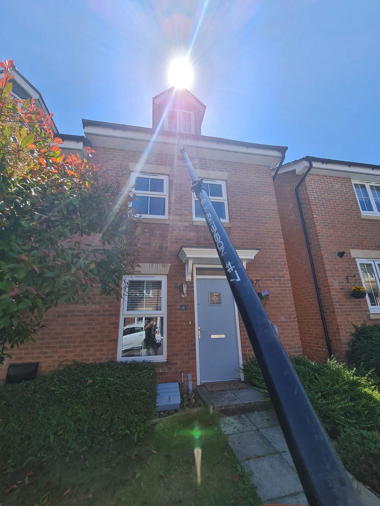 Reach and wash pole cleaning upper windows of a home