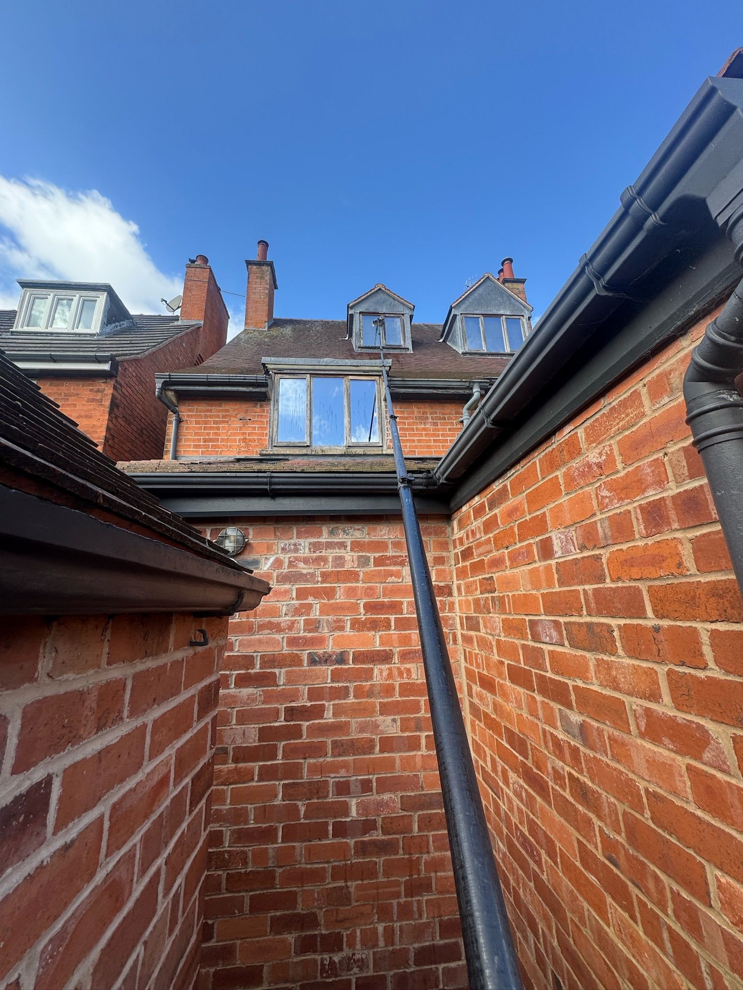 Water-fed pole reaching third-storey dormer windows from the ground